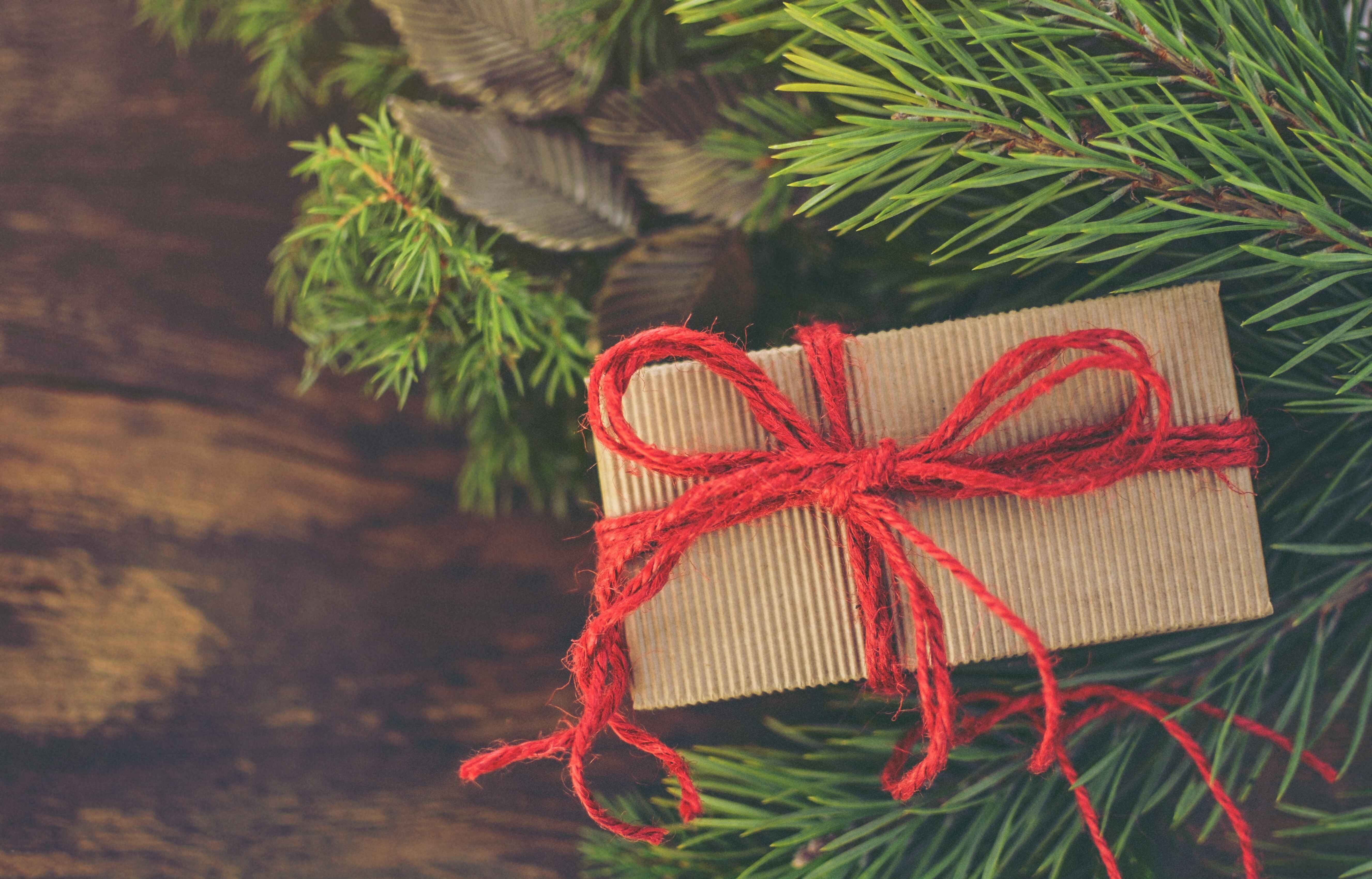 Gift wrapping made with recycled material with a red ribbon.