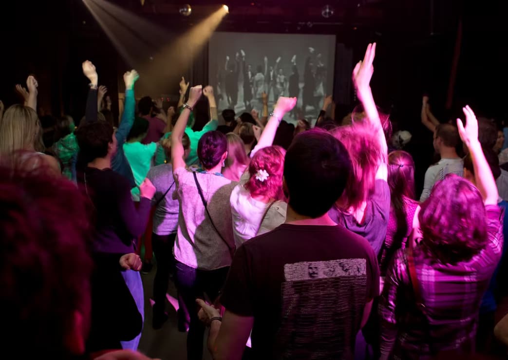 People dancing in front of a screen