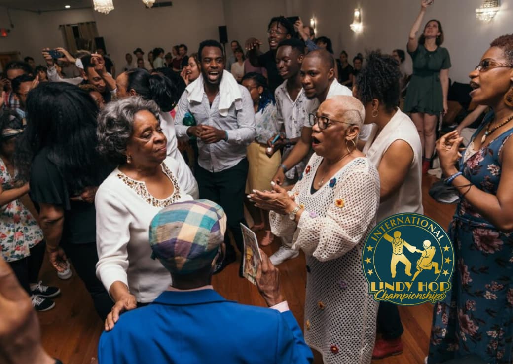 A group of people dancing swing and singing on a dance floor.