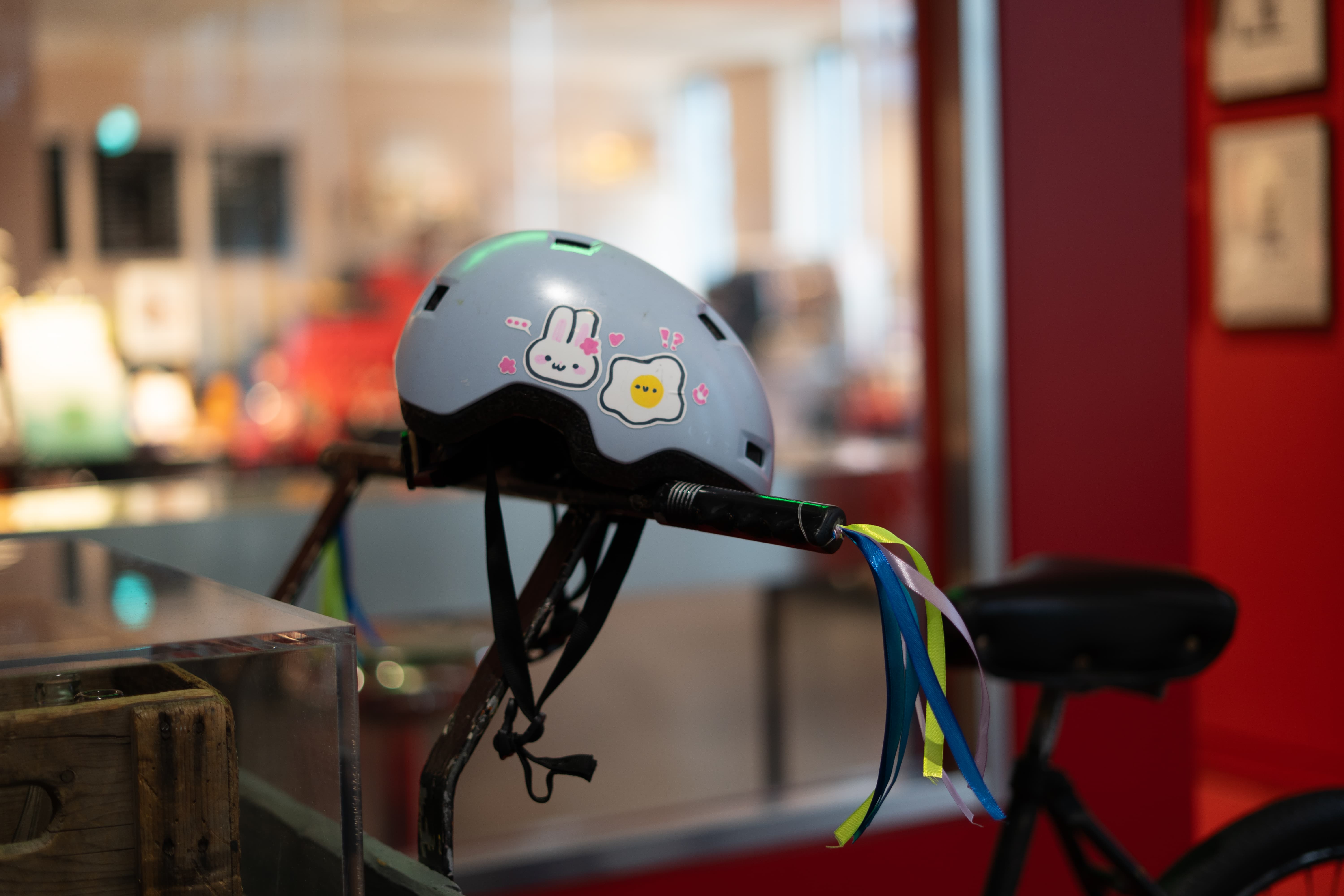 Helmet decorated with stickers and bicycle adorned with colorful ribbons.