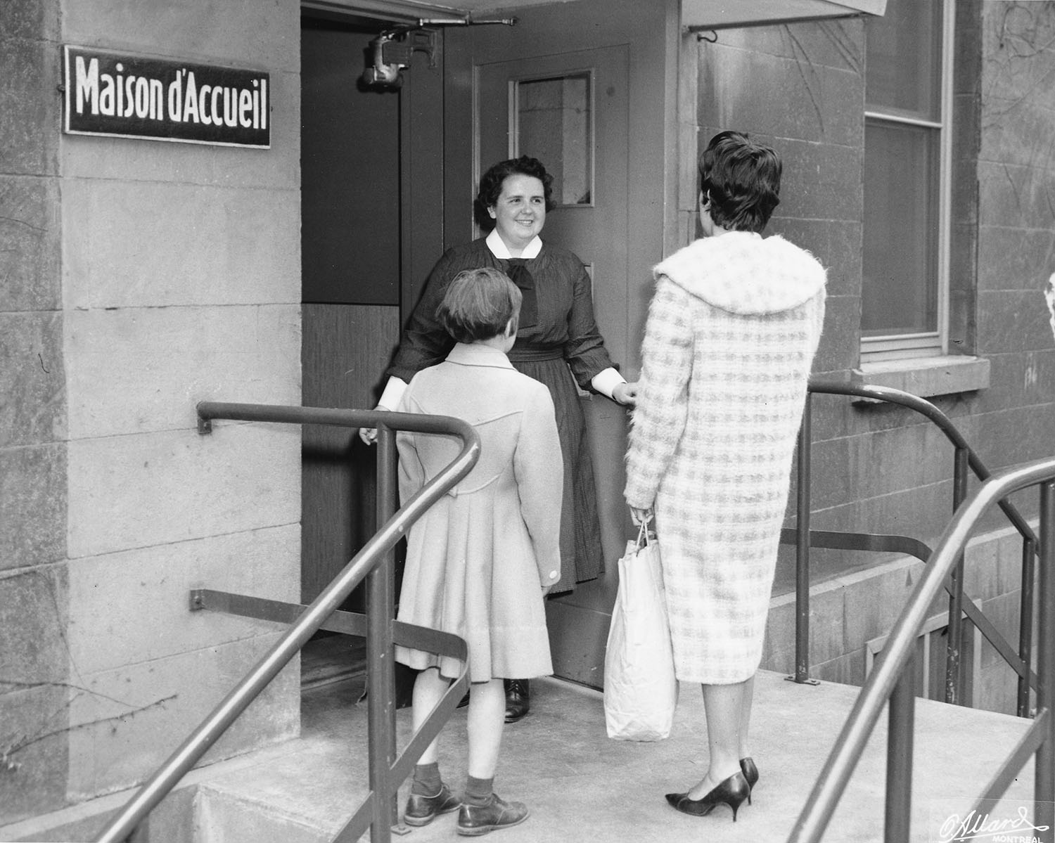 Photo noir et blanc d’une Associée accueillant une mère et sa fille au 101, rue De La Gauchetière.