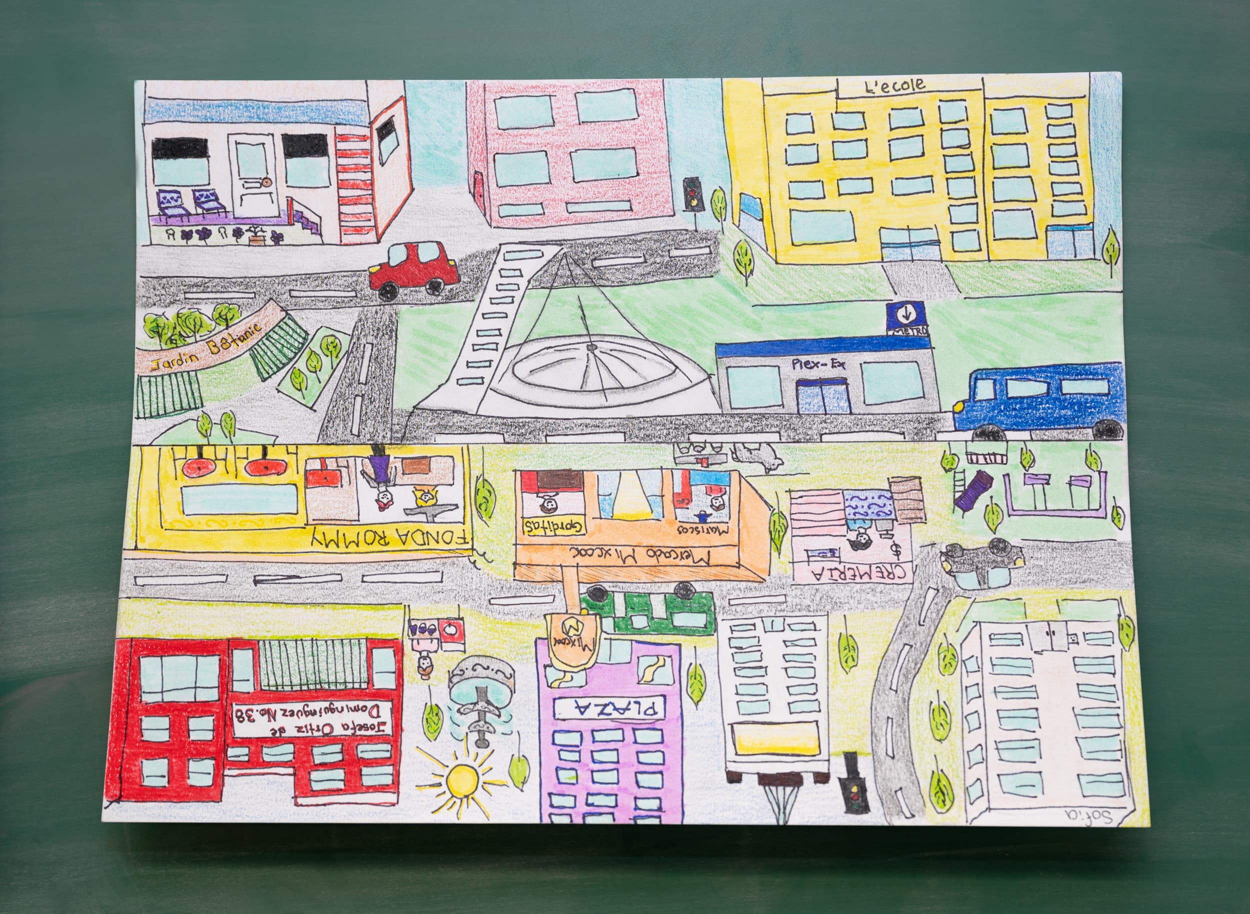 Dessin coloré d’un quartier avec rues, voitures, immeubles, commerces et une école vus de dessus.